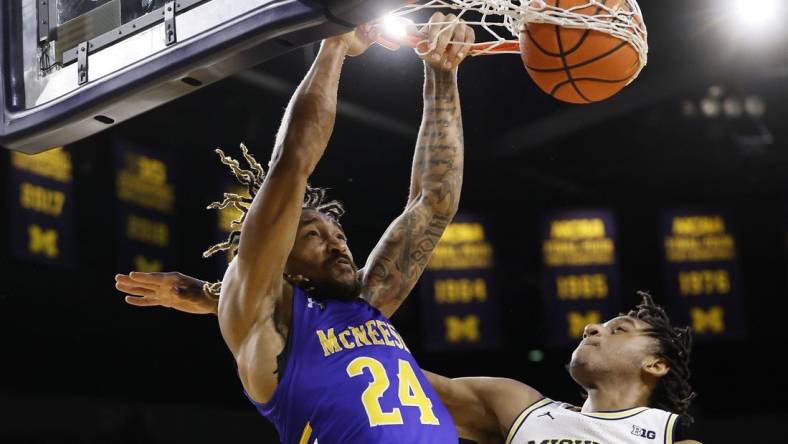 Dec 29, 2023; Ann Arbor, Michigan, USA;  McNeese State Cowboys forward Christian Shumate (24) dunks on Michigan Wolverines forward Tarris Reed Jr. (32) in the second half at Crisler Center. Mandatory Credit: Rick Osentoski-USA TODAY Sports