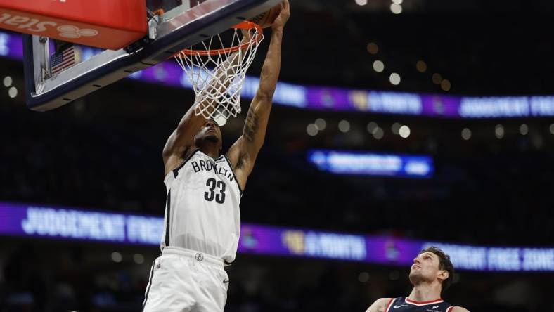 Dec 29, 2023; Washington, District of Columbia, USA; Brooklyn Nets center Nic Claxton (33) attempts to dunk the ball as Washington Wizards center Mike Muscala (35) looks on in the fourth quarter at Capital One Arena. Mandatory Credit: Geoff Burke-USA TODAY Sports