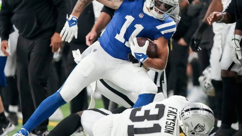 Indianapolis Colts wide receiver Michael Pittman Jr. (11) runs out of bounds as Las Vegas Raiders cornerback Brandon Facyson (31) rolls at his feet Sunday, Dec. 31, 2023, during a game against the Las Vegas Raiders at Lucas Oil Stadium in Indianapolis.