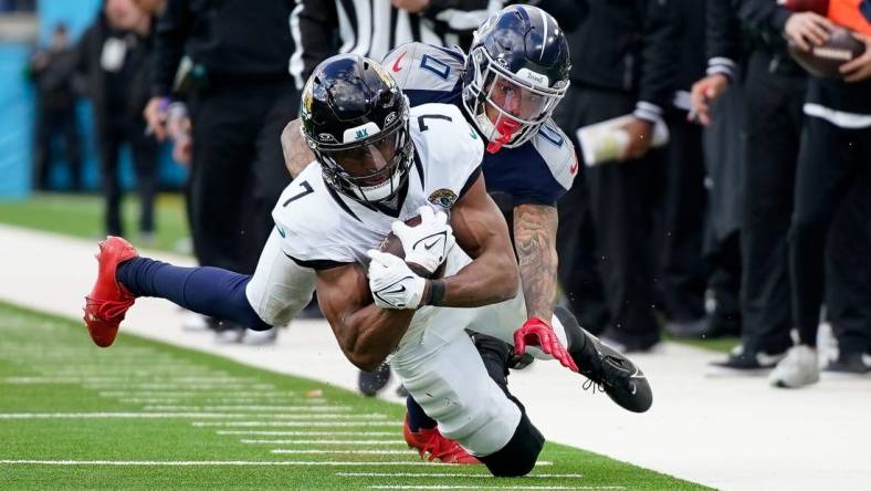 Tennessee Titans cornerback Sean Murphy-Bunting (0) tackles Jacksonville Jaguars wide receiver Zay Jones (7) during the third quarter at Nissan Stadium in Nashville, Tenn., Sunday, Jan. 7, 2024.