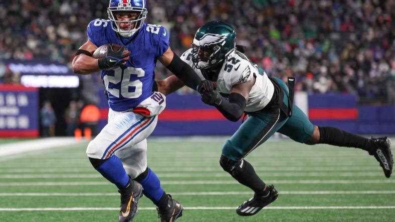 Jan 7, 2024; East Rutherford, New Jersey, USA; New York Giants running back Saquon Barkley (26) breaks a tackle by Philadelphia Eagles linebacker Zach Cunningham (52) for a rushing touchdown during the first half at MetLife Stadium. Mandatory Credit: Vincent Carchietta-USA TODAY Sports