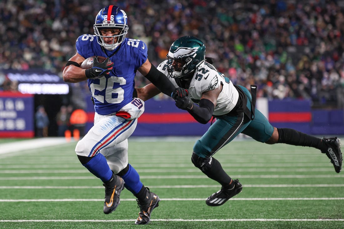 Jan 7, 2024; East Rutherford, New Jersey, USA; New York Giants running back Saquon Barkley (26) breaks a tackle by Philadelphia Eagles linebacker Zach Cunningham (52) for a rushing touchdown during the first half at MetLife Stadium. Mandatory Credit: Vincent Carchietta-USA TODAY Sports