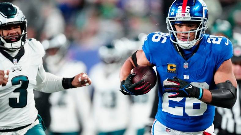 New York Giants running back Saquon Barkley (26) heads to the goal line in the second quarter past Philadelphia Eagles linebacker Nolan Smith (3), Sunday, January 7, 2024.