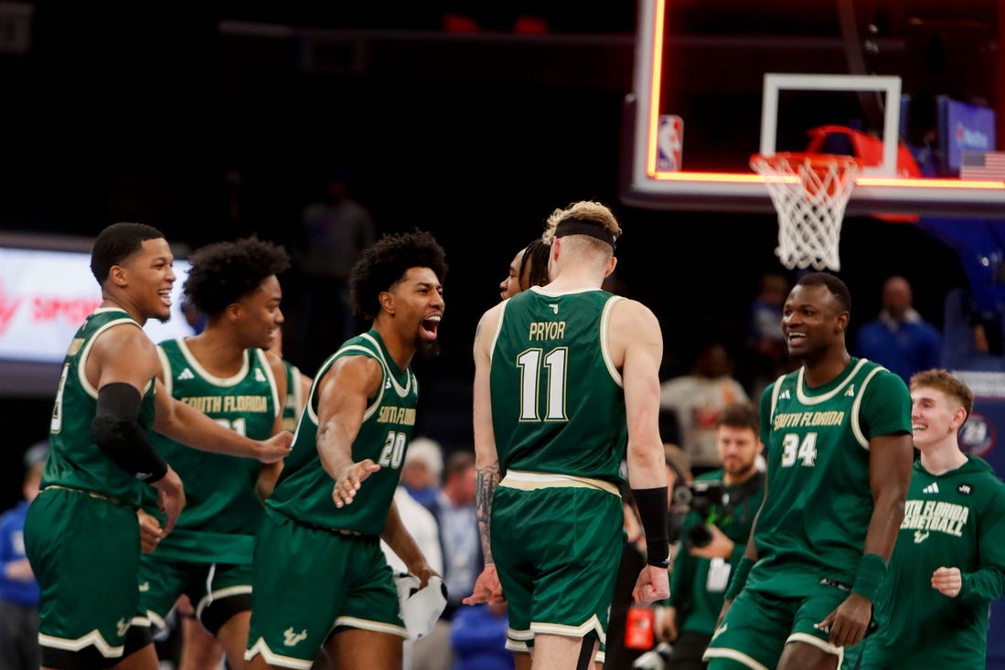 Jan 18, 2024; Memphis, Tennessee, USA; South Florida Bulls forward Sam Hines Jr. (20) slaps forward Kasean Pryor (11) on the back as the team celebrates as the buzzer sounds after defeating Memphis 74-73  at FedExForum. Mandatory Credit: Chris Day-USA TODAY Sports