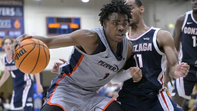 Jan 18, 2024; Malibu, California, USA; Pepperdine Waves guard Michael Ajayi (1) is defended by Gonzaga Bulldogs guard Nolan Hickman (11) in the second half at Firestone Fieldhouse. Mandatory Credit: Jayne Kamin-Oncea-USA TODAY Sports