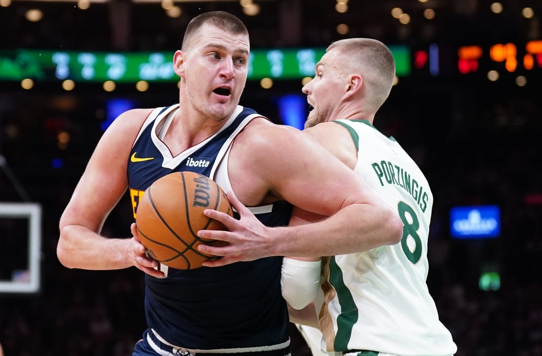 Jan 19, 2024; Boston, Massachusetts, USA; Denver Nuggets center Nikola Jokic (15) works the ball around Boston Celtics center Kristaps Porzingis (8) in the second quarter at TD Garden. Mandatory Credit: David Butler II-USA TODAY Sports