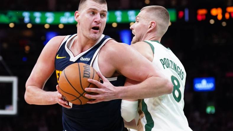 Jan 19, 2024; Boston, Massachusetts, USA; Denver Nuggets center Nikola Jokic (15) works the ball around Boston Celtics center Kristaps Porzingis (8) in the second quarter at TD Garden. Mandatory Credit: David Butler II-USA TODAY Sports