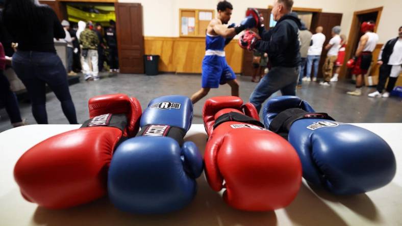 Michael Cappiello owner of Cappiello Boxing Gym with his boxer Will Longwe, 27, who hits the hand pads against Mchilandy Noel of Bishop's Gym in West Bridgewater during the Southern New England Golden Gloves opening night at the Fall River PAL Hall on Saturday, Jan. 20, 2024.