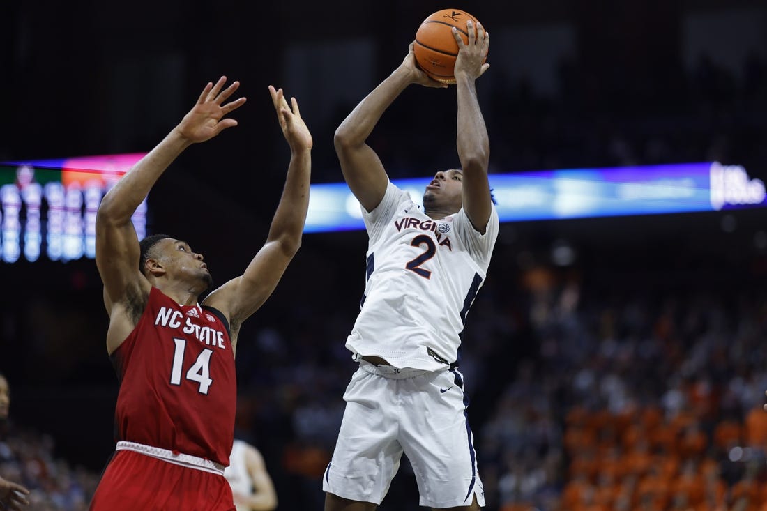 Jan 24, 2024; Charlottesville, Virginia, USA; Virginia Cavaliers guard Reece Beekman (2) shoots the ball as North Carolina State Wolfpack guard Casey Morsell (14) defends in overtime at John Paul Jones Arena. Mandatory Credit: Geoff Burke-USA TODAY Sports