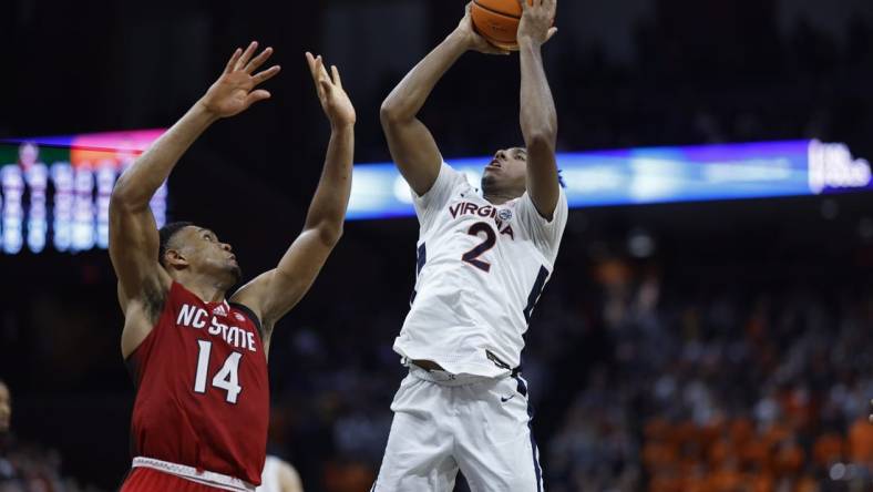 Jan 24, 2024; Charlottesville, Virginia, USA; Virginia Cavaliers guard Reece Beekman (2) shoots the ball as North Carolina State Wolfpack guard Casey Morsell (14) defends in overtime at John Paul Jones Arena. Mandatory Credit: Geoff Burke-USA TODAY Sports