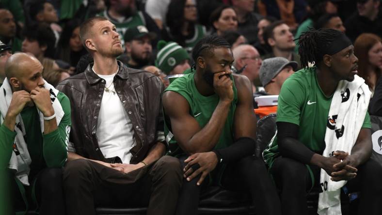 Jan 27, 2024; Boston, Massachusetts, USA;  Boston Celtics center Kristaps Porzingis (8) guard Jaylen Brown (7) and guard Jrue Holiday (4) on the bench during the second half against the LA Clippers at TD Garden. Mandatory Credit: Bob DeChiara-USA TODAY Sports