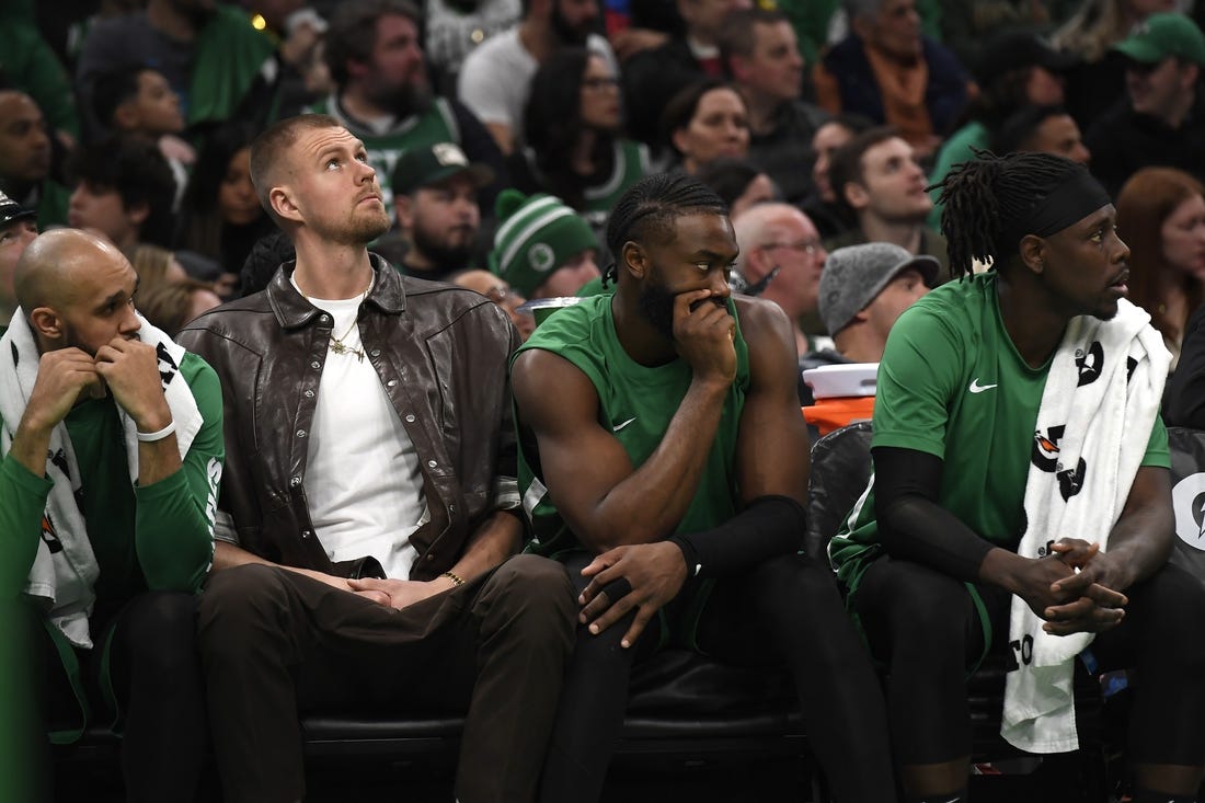 Jan 27, 2024; Boston, Massachusetts, USA;  Boston Celtics center Kristaps Porzingis (8) guard Jaylen Brown (7) and guard Jrue Holiday (4) on the bench during the second half against the LA Clippers at TD Garden. Mandatory Credit: Bob DeChiara-USA TODAY Sports