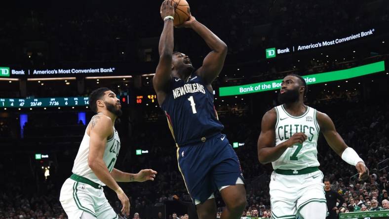 Jan 29, 2024; Boston, Massachusetts, USA;  New Orleans Pelicans forward Zion Williamson (1) shoots the ball between Boston Celtics forward Jayson Tatum (0) and guard Jaylen Brown (7) during the second half at TD Garden. Mandatory Credit: Bob DeChiara-USA TODAY Sports