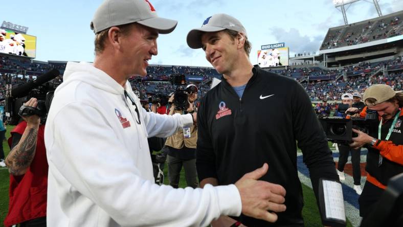 Feb 4, 2024; Orlando, FL, USA; NFC coach Eli Manning and AFC coach Peyton Manning react after the 2024 Pro Bowl at Camping World Stadium. Mandatory Credit: Nathan Ray Seebeck-USA TODAY Sports