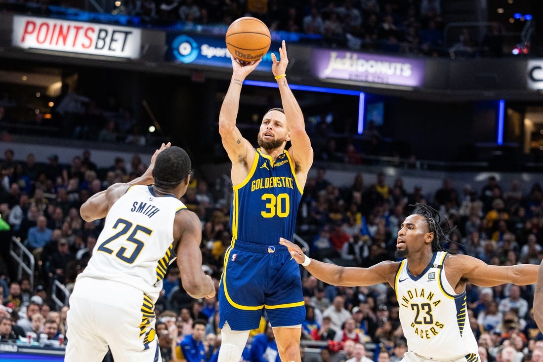 Feb 8, 2024; Indianapolis, Indiana, USA; Golden State Warriors guard Stephen Curry (30) shoots the ball while Indiana Pacers forward Jalen Smith (25) and forward Aaron Nesmith (23)  defend in the first half at Gainbridge Fieldhouse. Mandatory Credit: Trevor Ruszkowski-USA TODAY Sports