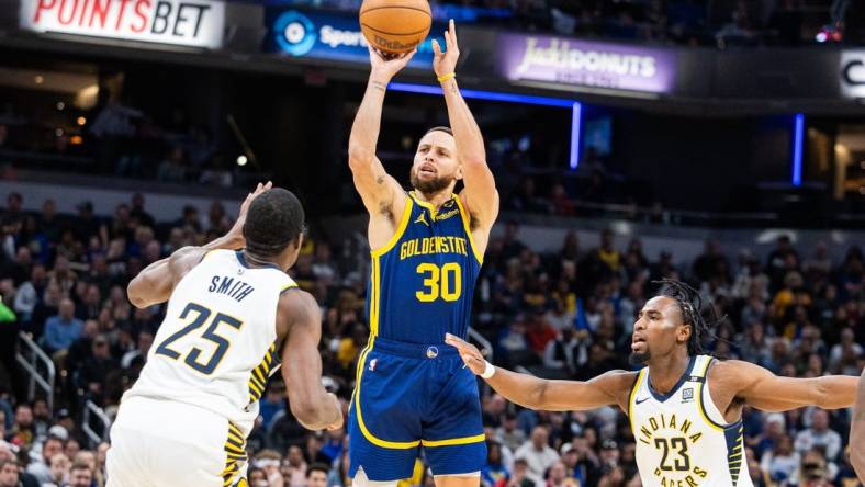 Feb 8, 2024; Indianapolis, Indiana, USA; Golden State Warriors guard Stephen Curry (30) shoots the ball while Indiana Pacers forward Jalen Smith (25) and forward Aaron Nesmith (23)  defend in the first half at Gainbridge Fieldhouse. Mandatory Credit: Trevor Ruszkowski-USA TODAY Sports