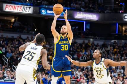 Feb 8, 2024; Indianapolis, Indiana, USA; Golden State Warriors guard Stephen Curry (30) shoots the ball while Indiana Pacers forward Jalen Smith (25) and forward Aaron Nesmith (23)  defend in the first half at Gainbridge Fieldhouse. Mandatory Credit: Trevor Ruszkowski-USA TODAY Sports