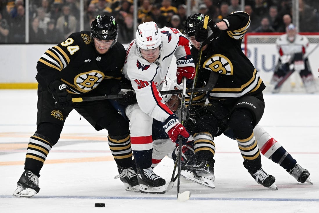 Feb 10, 2024; Boston, Massachusetts, USA; Washington Capitals right wing Nicolas Aube-Kubel (96) battles for the puck against Boston Bruins center Jakub Lauko (94) and center Morgan Geekie (39) during the second period at the TD Garden. Mandatory Credit: Brian Fluharty-USA TODAY Sports