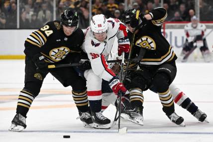 Feb 10, 2024; Boston, Massachusetts, USA; Washington Capitals right wing Nicolas Aube-Kubel (96) battles for the puck against Boston Bruins center Jakub Lauko (94) and center Morgan Geekie (39) during the second period at the TD Garden. Mandatory Credit: Brian Fluharty-USA TODAY Sports