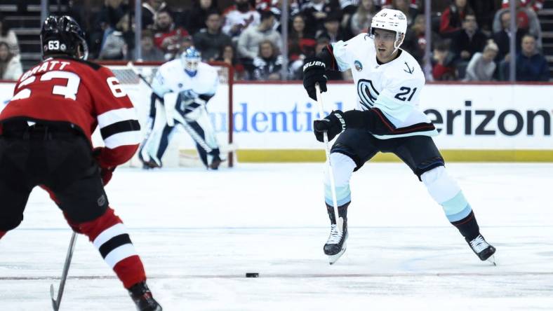 Feb 12, 2024; Newark, New Jersey, USA; Seattle Kraken center Alex Wennberg (21) skates with the puck against as New Jersey Devils left wing Jesper Bratt (63) defends during the first period at Prudential Center. Mandatory Credit: John Jones-USA TODAY Sports