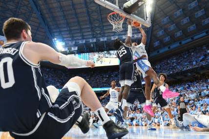 Feb 3, 2024; Chapel Hill, North Carolina, USA; North Carolina Tar Heels forward Armando Bacot (5) shoots as Duke Blue Devils forward Mark Mitchell (25) defends and center Kyle Filipowski (30) sits on the floor in the second half at Dean E. Smith Center. Mandatory Credit: Bob Donnan-USA TODAY Sports