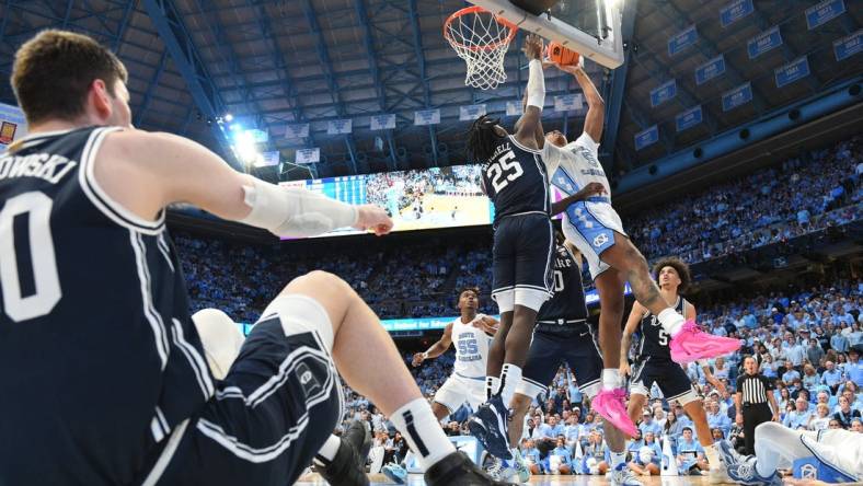 Feb 3, 2024; Chapel Hill, North Carolina, USA; North Carolina Tar Heels forward Armando Bacot (5) shoots as Duke Blue Devils forward Mark Mitchell (25) defends and center Kyle Filipowski (30) sits on the floor in the second half at Dean E. Smith Center. Mandatory Credit: Bob Donnan-USA TODAY Sports