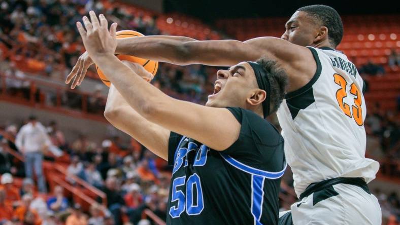 Feb 17, 2024; Stillwater, Oklahoma, USA; Oklahoma State Cowboys center Brandon Garrison (23) gets tangled up with Brigham Young Cougars center Aly Khalifa (50) during the second half at Gallagher-Iba Arena. Mandatory Credit: William Purnell-USA TODAY Sports