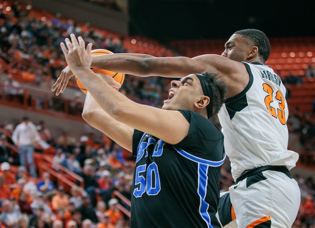 Feb 17, 2024; Stillwater, Oklahoma, USA; Oklahoma State Cowboys center Brandon Garrison (23) gets tangled up with Brigham Young Cougars center Aly Khalifa (50) during the second half at Gallagher-Iba Arena. Mandatory Credit: William Purnell-USA TODAY Sports