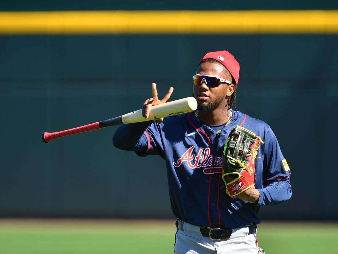 Atlanta Braves outfielder Ronald Acuna, Jr. makes a sign for a video drone following players as the enter the stadium for the first full squad workout on Tuesday, Feb. 20, 2024 at CoolToday Park in North Port, Florida.