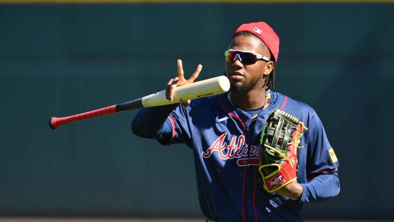 Atlanta Braves outfielder Ronald Acuna, Jr. makes a sign for a video drone following players as the enter the stadium for the first full squad workout on Tuesday, Feb. 20, 2024 at CoolToday Park in North Port, Florida.