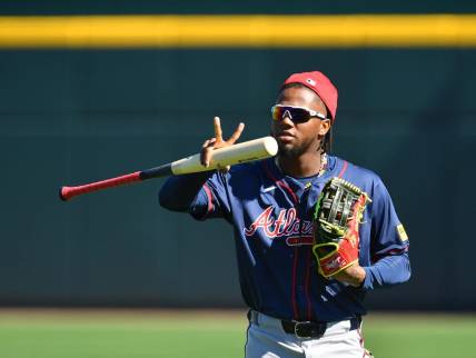Atlanta Braves outfielder Ronald Acuna, Jr. makes a sign for a video drone following players as the enter the stadium for the first full squad workout on Tuesday, Feb. 20, 2024 at CoolToday Park in North Port, Florida.
