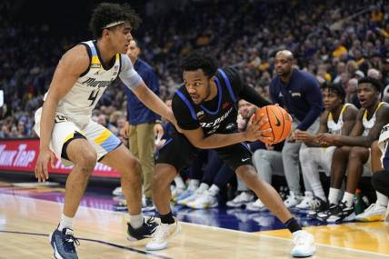 Feb 21, 2024; Milwaukee, Wisconsin, USA;  DePaul Blue Demons guard Chico Carter Jr. (2) holds the ball away from Marquette Golden Eagles guard Stevie Mitchell (4) during the first half at Fiserv Forum. Mandatory Credit: Jeff Hanisch-USA TODAY Sports