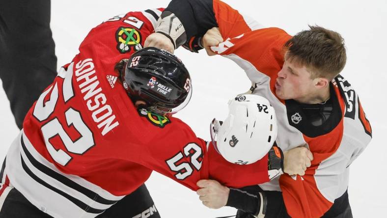 Feb 21, 2024; Chicago, Illinois, USA; Philadelphia Flyers defenseman Nick Seeler (24) fights with Chicago Blackhawks center Reese Johnson (52) during the third period at United Center. Mandatory Credit: Kamil Krzaczynski-USA TODAY Sports