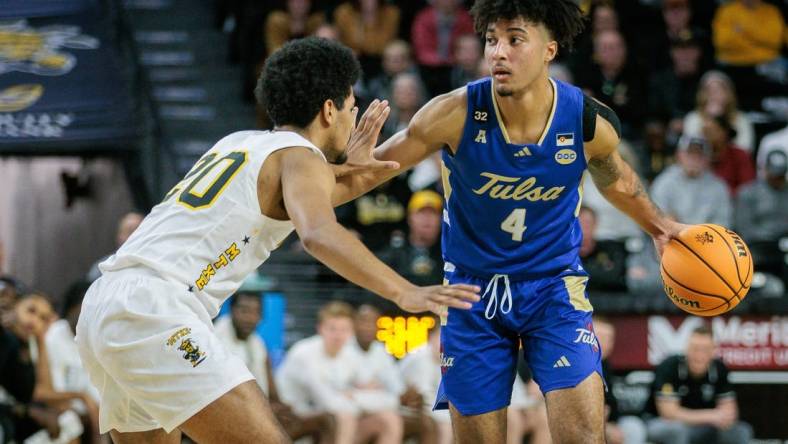 Feb 21, 2024; Wichita, Kansas, USA; Tulsa Golden Hurricane guard PJ Haggerty (4) brings the ball up court around Wichita State Shockers guard Harlond Beverly (20) during the second half at Charles Koch Arena. Mandatory Credit: William Purnell-USA TODAY Sports