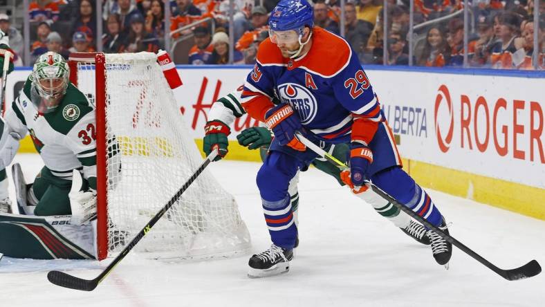 Feb 23, 2024; Edmonton, Alberta, CAN; Edmonton Oilers forward Leon Draisaitl (29) looks to make a pass in front of Minnesota Wild defensemen Dakota Mermis (6) during the first period at Rogers Place. Mandatory Credit: Perry Nelson-USA TODAY Sports