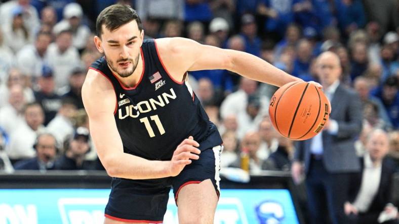 Feb 20, 2024; Omaha, Nebraska, USA;  Connecticut Huskies forward Alex Karaban (11) dribbles against the Creighton Bluejays in the first half at CHI Health Center Omaha. Mandatory Credit: Steven Branscombe-USA TODAY Sports