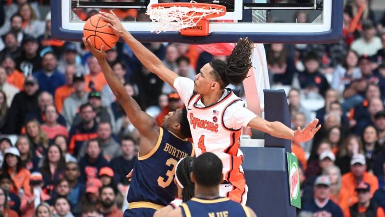 Feb 24, 2024; Syracuse, New York, USA; Syracuse Orange forward Chris Bell (4) blocks a shot by Notre Dame Fighting Irish guard Markus Burton (3) in the second half at the JMA Wireless Dome. Mandatory Credit: Mark Konezny-USA TODAY Sports