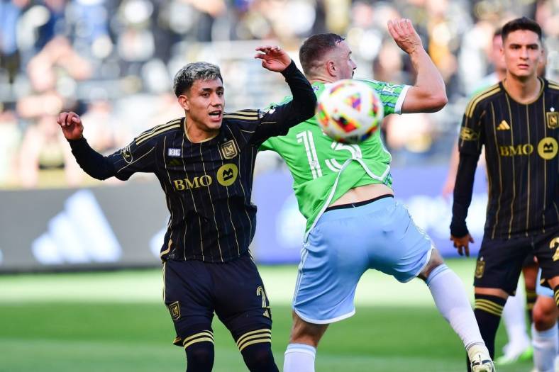 Feb 24, 2024; Los Angeles, California, USA; LAFC defender Omar Campos (2) plays for the ball against Seattle Sounders FC forward Jordan Morris (13) during the first half at BMO Stadium. Mandatory Credit: Gary A. Vasquez-USA TODAY Sports