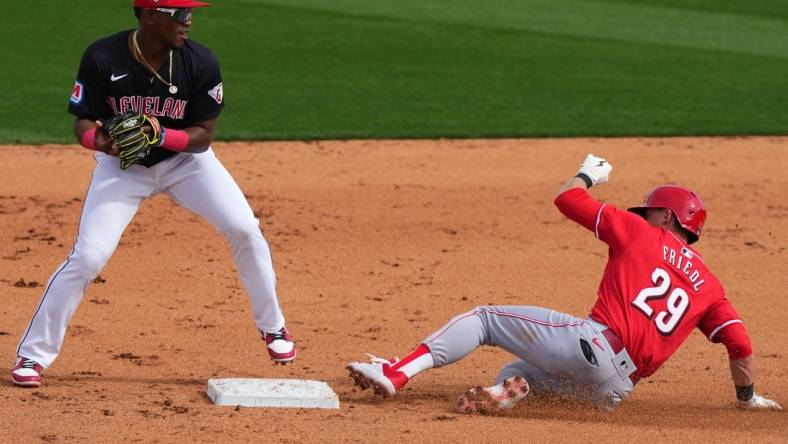 Cincinnati Reds center fielder TJ Friedl (29) slides into the second base on a double play turned by the Cleveland Guardians defense in the fifth inning during a MLB spring training baseball game, Saturday, Feb. 24, 2024, at Goodyear Ballpark in Goodyear, Ariz.