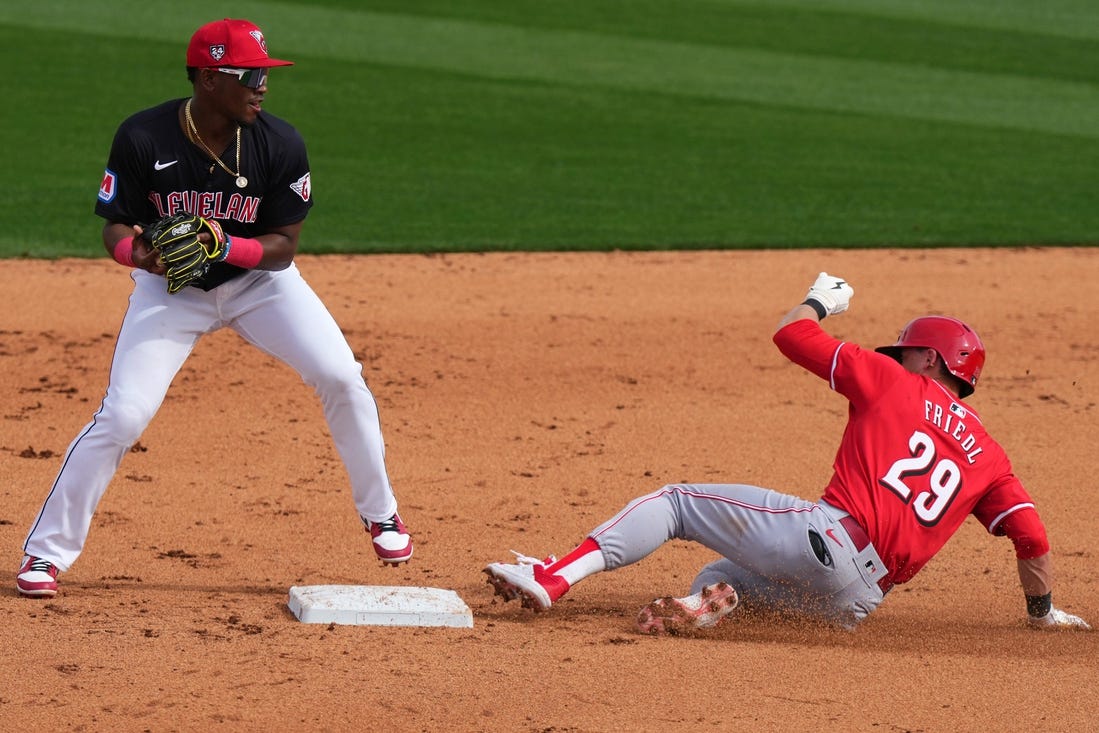 Cincinnati Reds center fielder TJ Friedl (29) slides into the second base on a double play turned by the Cleveland Guardians defense in the fifth inning during a MLB spring training baseball game, Saturday, Feb. 24, 2024, at Goodyear Ballpark in Goodyear, Ariz.