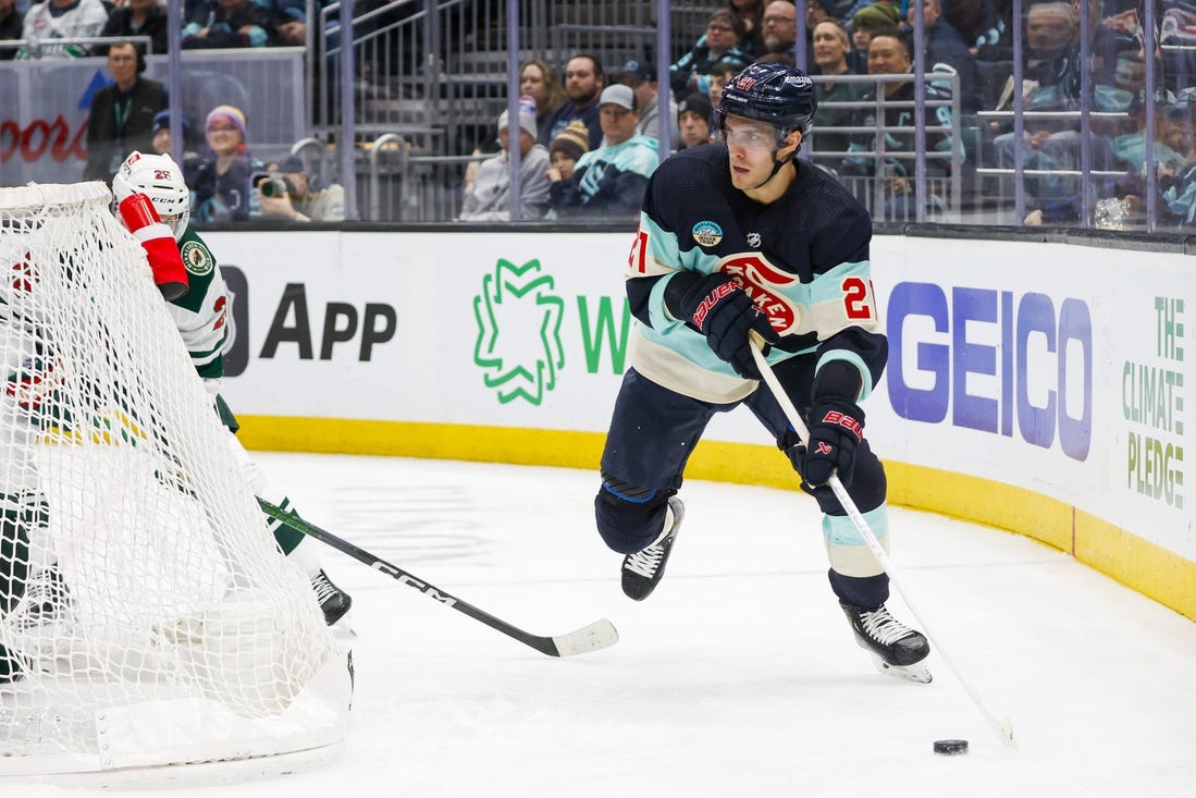 Feb 24, 2024; Seattle, Washington, USA; Seattle Kraken center Alex Wennberg (21) skates with the puck behind the net against the Minnesota Wild during the third period at Climate Pledge Arena. Mandatory Credit: Joe Nicholson-USA TODAY Sports