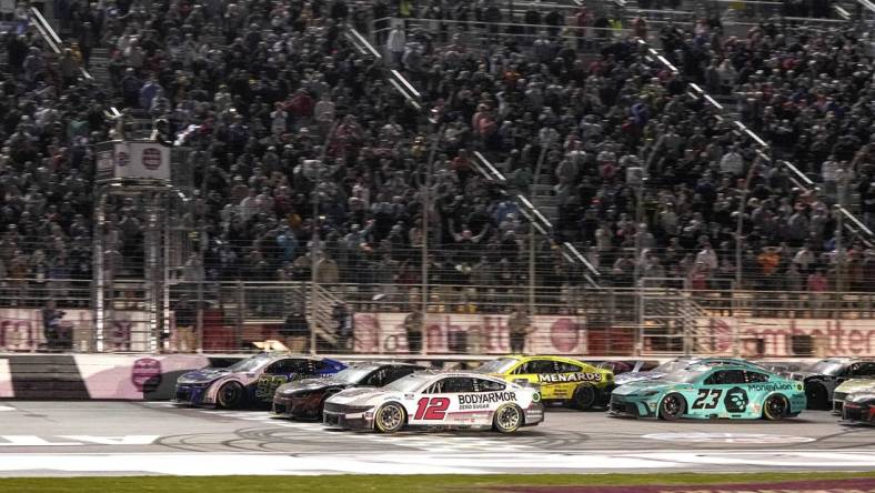 Feb 25, 2024; Hampton, Georgia, USA; NASCAR Cup Series driver Daniel Suarez (99) (near wall) beats NASCAR Cup Series driver Ryan Blaney (12) to the line to win the Ambetter Health 400 at Atlanta Motor Speedway. Mandatory Credit: David Yeazell-USA TODAY Sports