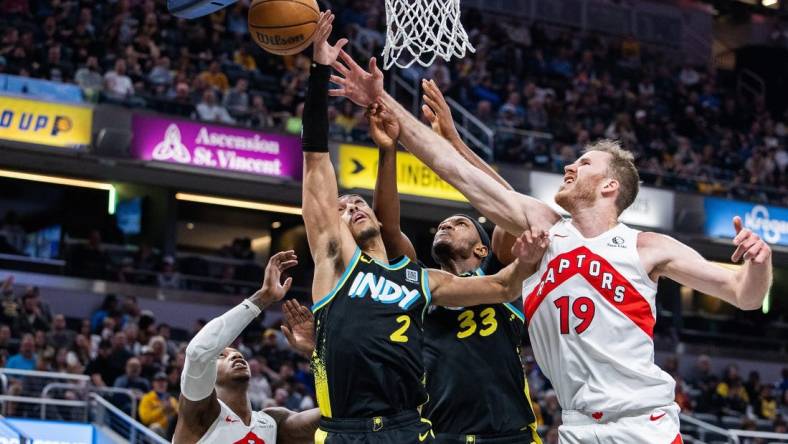 Feb 26, 2024; Indianapolis, Indiana, USA; Indiana Pacers guard Andrew Nembhard (2) shoots the ball while Toronto Raptors center Jakob Poeltl (19) defends in the second half at Gainbridge Fieldhouse. Mandatory Credit: Trevor Ruszkowski-USA TODAY Sports