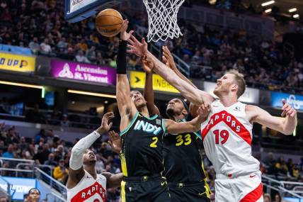 Feb 26, 2024; Indianapolis, Indiana, USA; Indiana Pacers guard Andrew Nembhard (2) shoots the ball while Toronto Raptors center Jakob Poeltl (19) defends in the second half at Gainbridge Fieldhouse. Mandatory Credit: Trevor Ruszkowski-USA TODAY Sports
