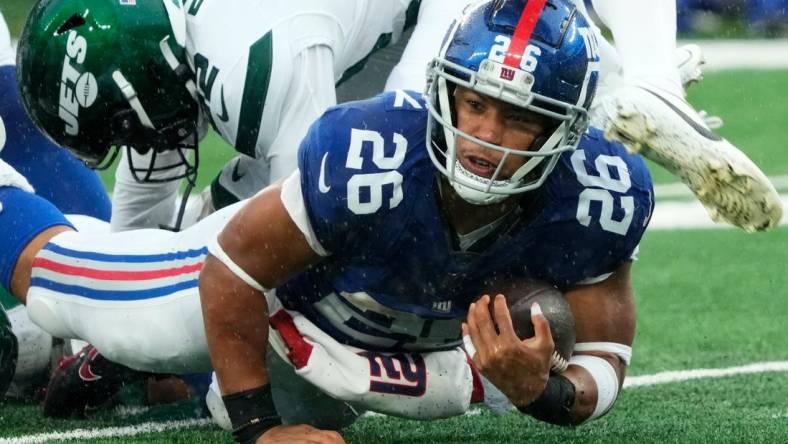 New York Giants running back Saquon Barkley (26) is shown with the ball against the Jets. The Giants' star running back is on the verge of hitting free agency and there is plenty of debate over his uncertain future with Big Blue.