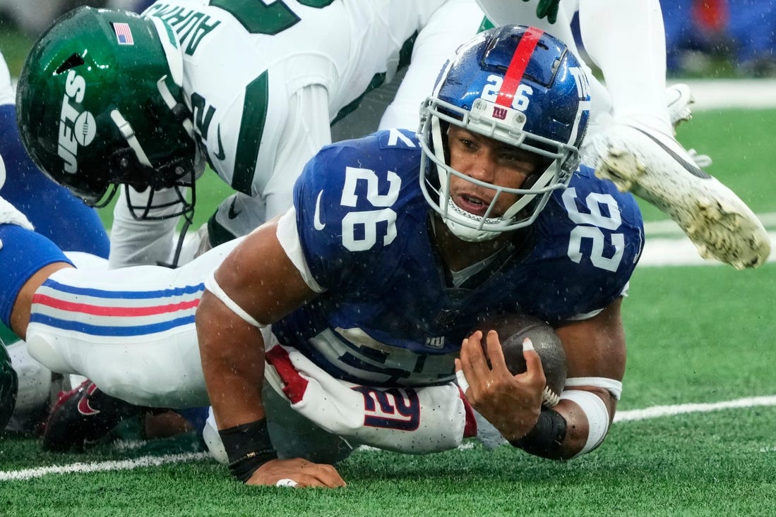 New York Giants running back Saquon Barkley (26) is shown with the ball against the Jets. The Giants' star running back is on the verge of hitting free agency and there is plenty of debate over his uncertain future with Big Blue.