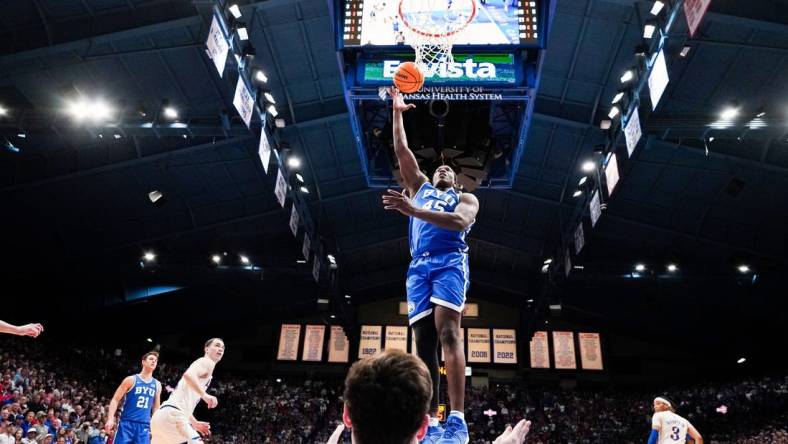 Feb 27, 2024; Lawrence, Kansas, USA; Brigham Young Cougars forward Fousseyni Traore (45) shoots as Kansas Jayhawks forward Parker Braun (23) falls below him during the second half at Allen Fieldhouse. Mandatory Credit: Denny Medley-USA TODAY Sports