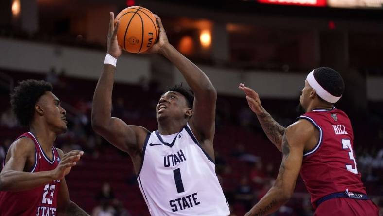 Feb 27, 2024; Fresno, California, USA; Utah State Aggies forward Great Osobor (1) drives to the hoop between Fresno State Bulldogs guard Leo Colimerio (23) and guard Isaiah Hill (3) in the first half at the Save Mart Center. Mandatory Credit: Cary Edmondson-USA TODAY Sports