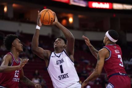 Feb 27, 2024; Fresno, California, USA; Utah State Aggies forward Great Osobor (1) drives to the hoop between Fresno State Bulldogs guard Leo Colimerio (23) and guard Isaiah Hill (3) in the first half at the Save Mart Center. Mandatory Credit: Cary Edmondson-USA TODAY Sports