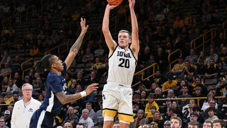 Feb 27, 2024; Iowa City, Iowa, USA; Iowa Hawkeyes forward Payton Sandfort (20) shoots a three point basket over Penn State Nittany Lions guard Nick Kern Jr. (3) as head coach Fran McCaffery looks on during the second half at Carver-Hawkeye Arena. Mandatory Credit: Jeffrey Becker-USA TODAY Sports